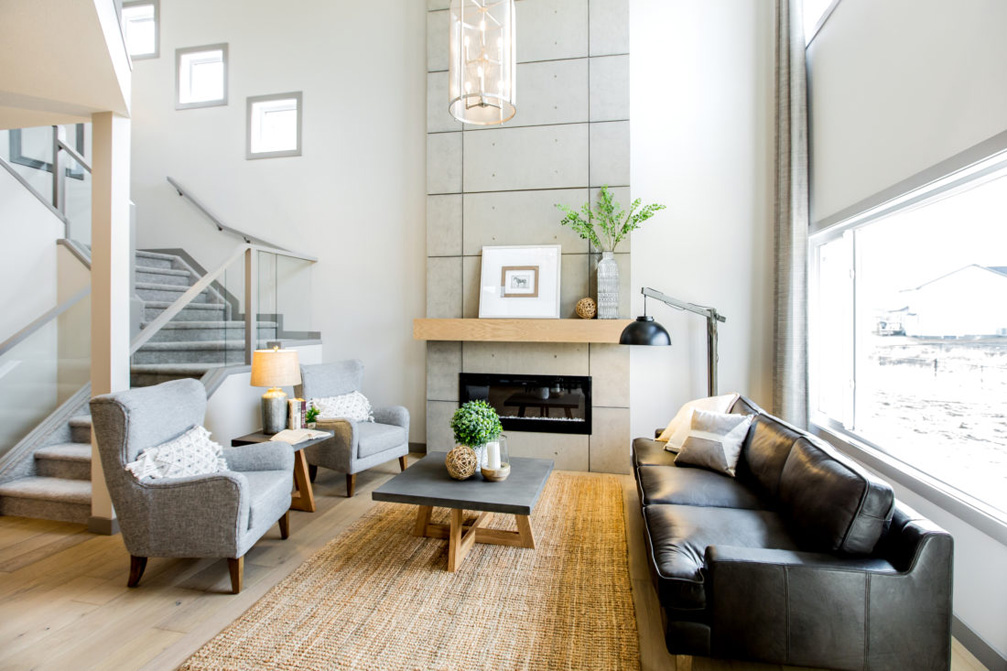Stylish showhome in Spruce Grove. Modern living room with fireplace and black sofa.